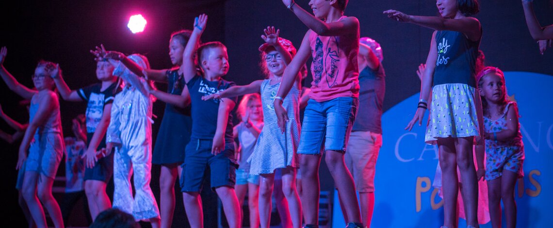 enfant sur scene pour soirée disco camping