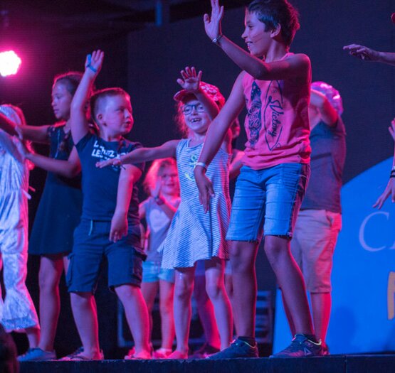 enfant sur scene pour soirée disco camping