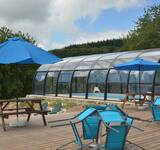 terrasse et pique nique au bord de la piscine couverte du Camping Paradis Les Chanterelles