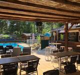 terrasse avec vue sur la piscine du Camping Paradis Les Relarguiers