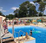 enfant sur le pont au dessus de la piscine extérieure au camping Pomme de Pin