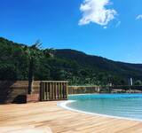 piscine extérieure et montagnes en arrière plan au camping La Roudelière