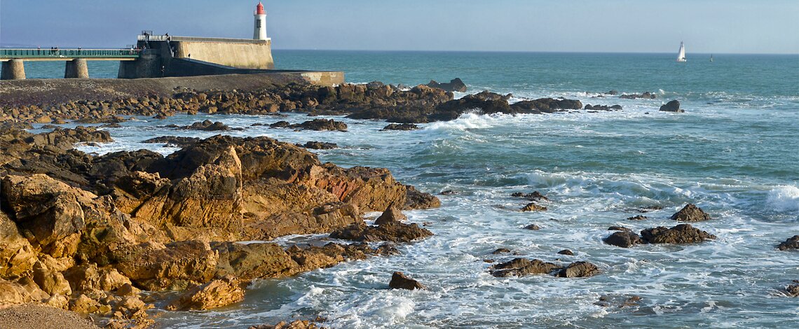 Photo de l'océan avec les rochers et un phare