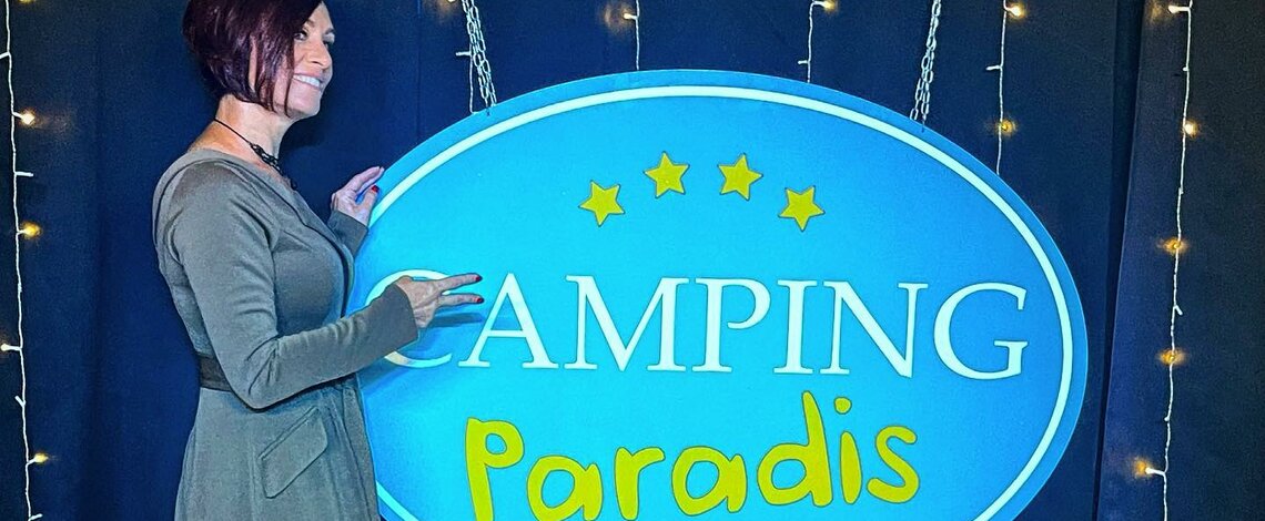 Alex Dana devant le logo Camping Paradis