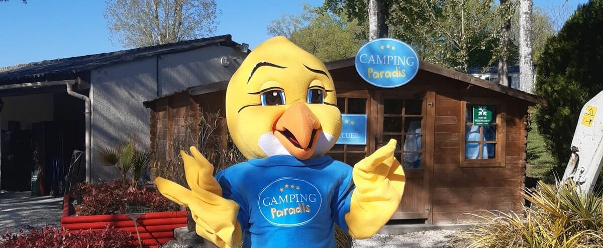 la mascotte Piki dans l'un des Campings Paradis, devant un chalet